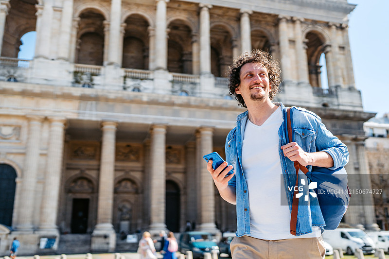 在法国巴黎圣叙尔皮斯教堂前使用手机的年轻男人图片素材