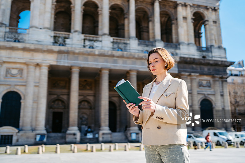 在法国巴黎圣叙尔皮斯教堂前阅读书籍的大学生图片素材