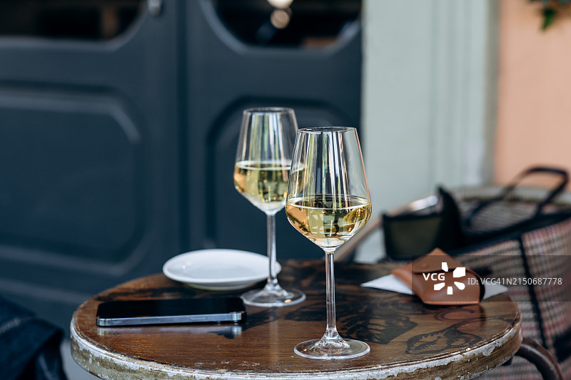 欧洲城市街头酒吧桌上的两杯白葡萄酒图片素材