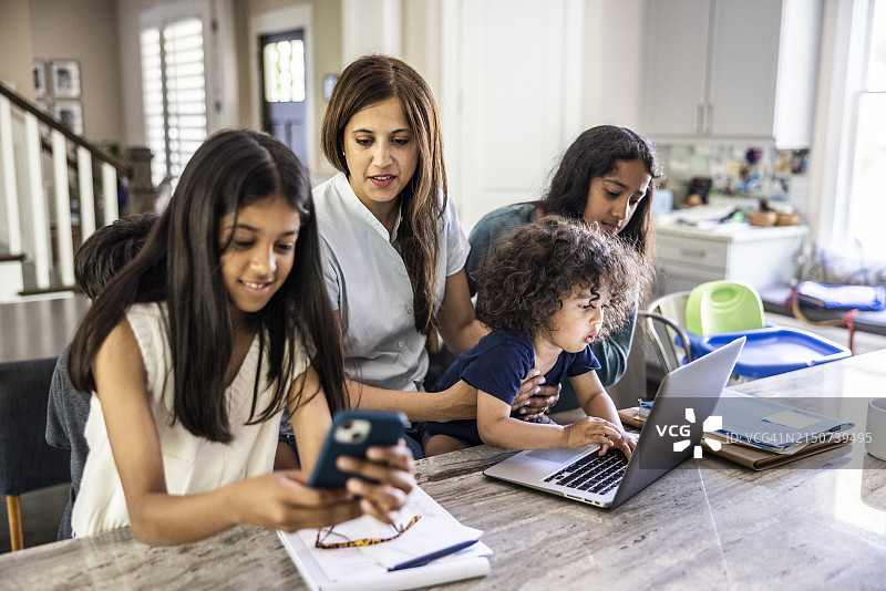 在家工作，同时照顾四个孩子的母亲图片素材