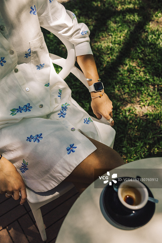 穿着时尚在户外享受咖啡的年轻女人图片素材