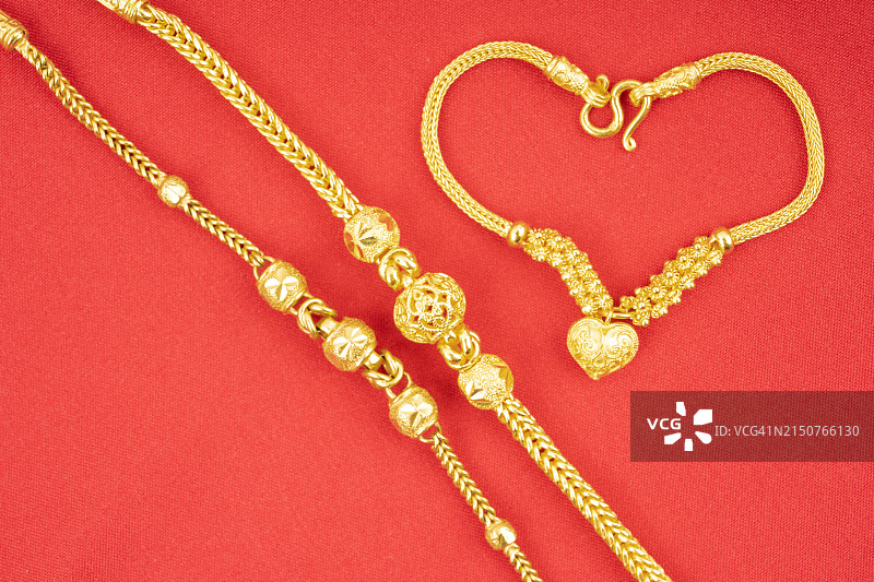 红色天鹅绒上的金项链和手镯图片素材