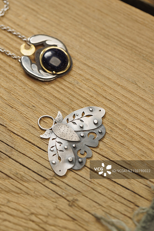 珠宝商在木桌上手工制作锁骨吊坠图片素材