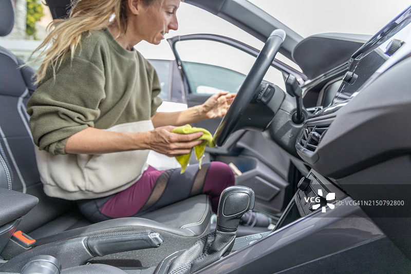 年轻女人清洁她的汽车图片素材