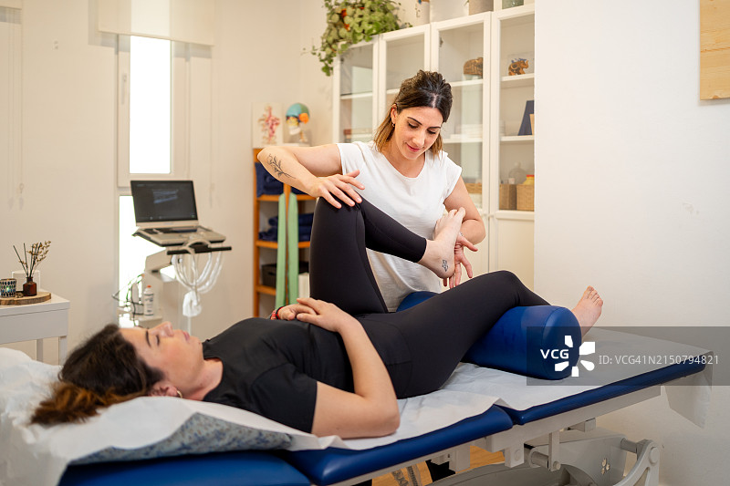 诊所内，脊椎按摩师正在治疗患者的膝盖图片素材
