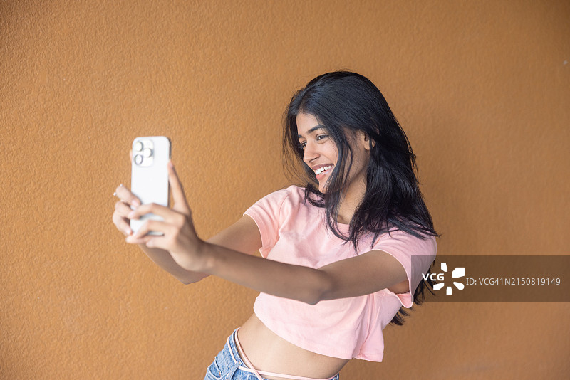 印度女孩在纹理背景前自拍图片素材