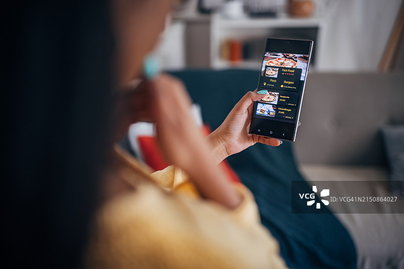 女人在手机上浏览外卖应用程序图片素材