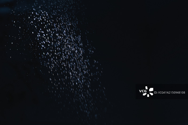 黑暗背景下散落的水滴，极简动态捕捉。图片素材