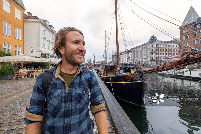 男人在哥本哈根的 Nyhavn 运河边散步图片素材