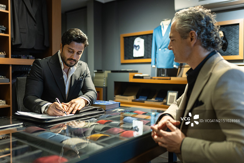 私人裁缝为商务客户的新西装做笔记图片素材