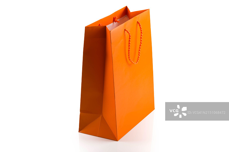 白色背景上的橙色纸质购物袋，对角线角度图片素材