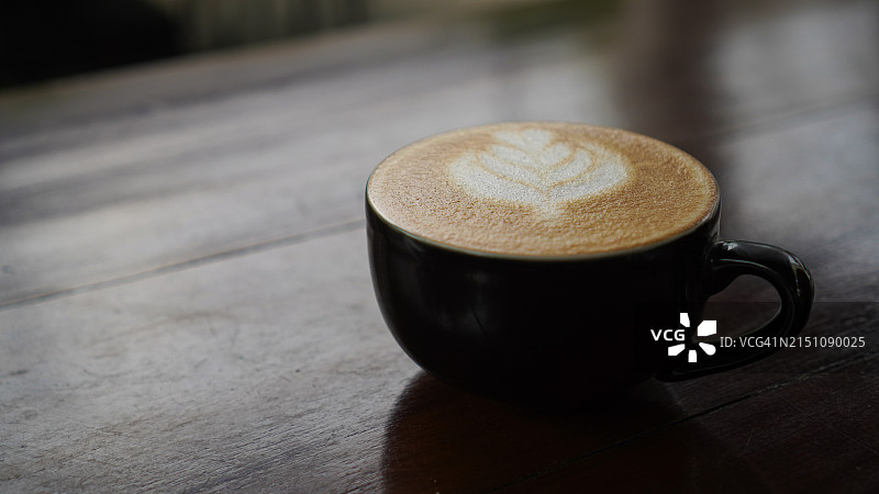 木桌上的拿铁咖啡杯图片素材