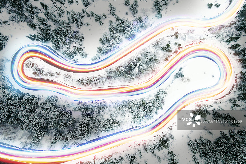 弯曲山路与动态汽车光轨鸟瞰图片素材