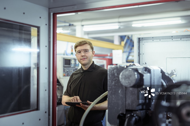 工程学徒在工厂使用车床和电脑图片素材