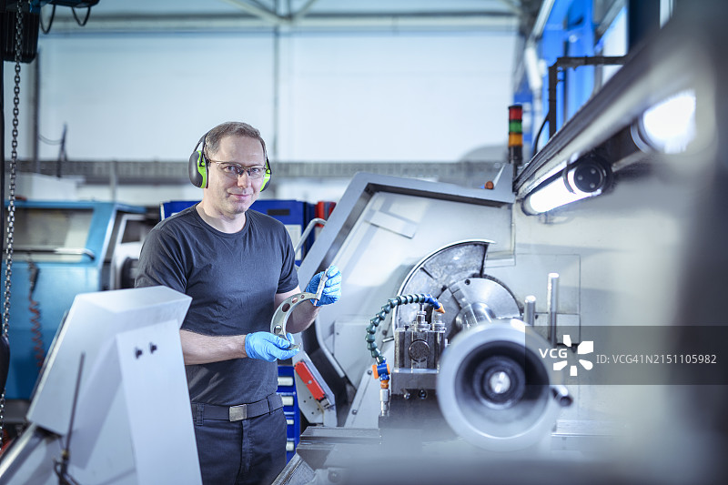 在工程厂车床上工作的工程师图片素材