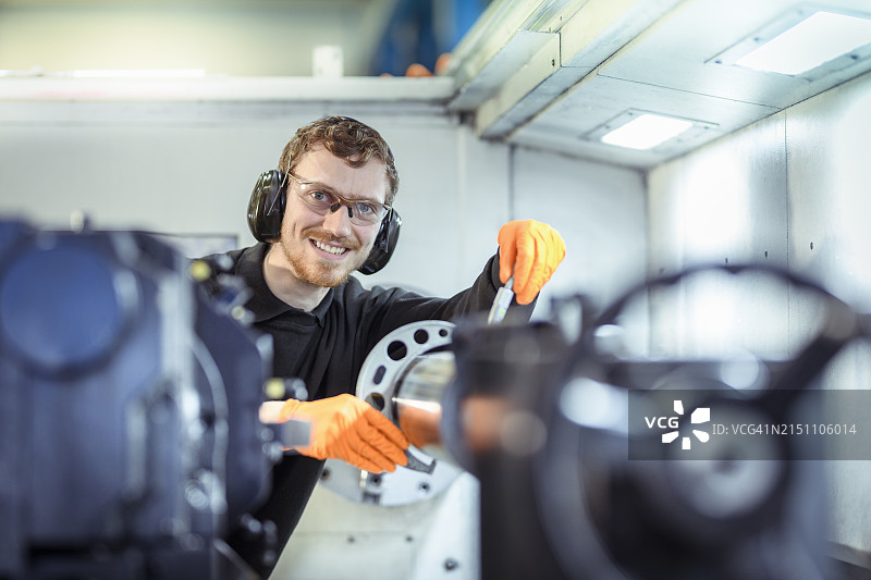 工程师在工程工厂中使用超声波探伤对车床上钢件进行裂纹测试图片素材