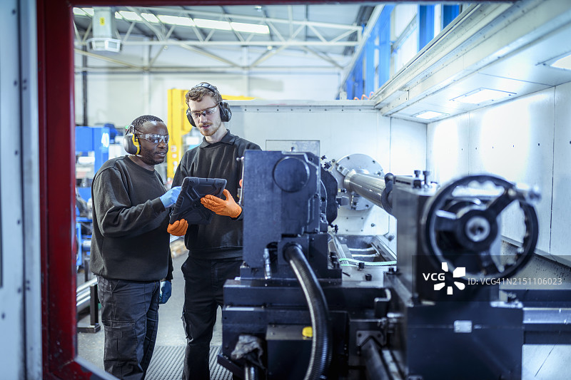 工程师在工厂用平板电脑讨论数据图片素材