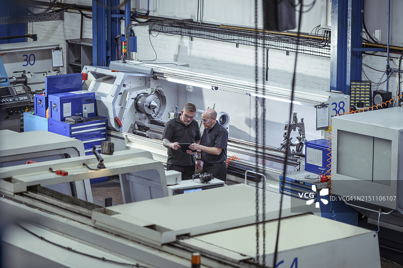 工程师在工厂讨论数字平板电脑上的数据图片素材