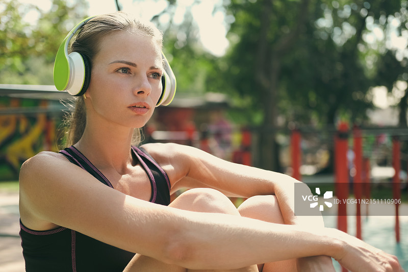 戴耳机在户外健身的年轻女人图片素材