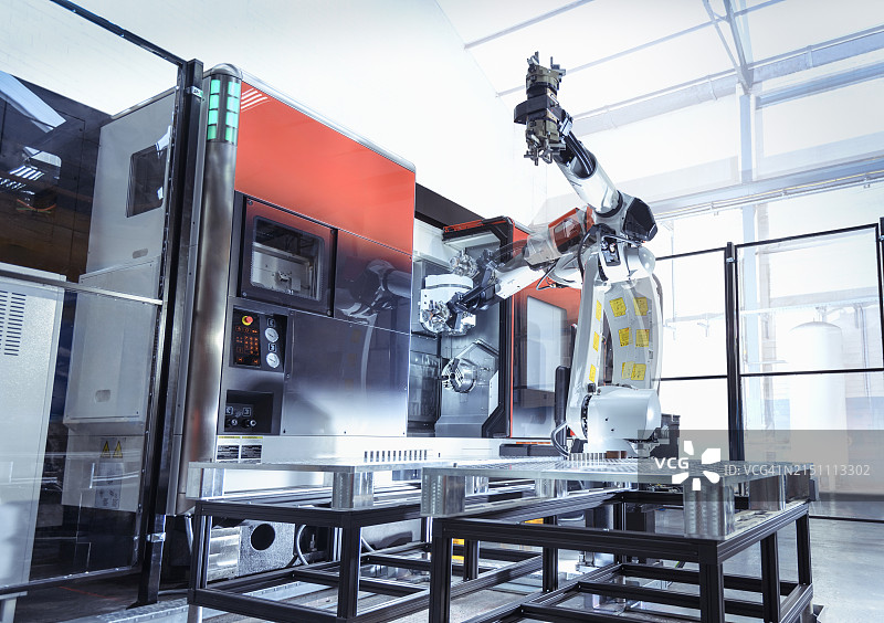 工程工厂中机器人和数控机床的多次曝光图片素材