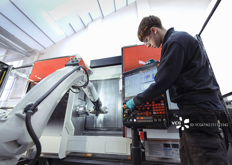 工程师在工程工厂控制数控机器人图片素材