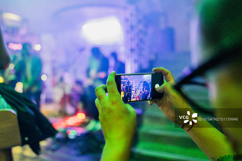 男子在夜总会拍摄摇滚乐队表演图片素材