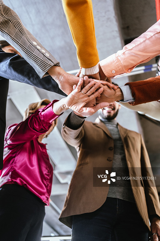 在办公室里手叠在一起的同事们图片素材