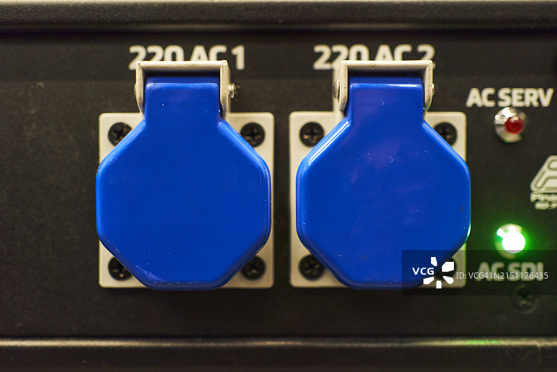 带有蓝色盖子的Schuko插头在电气面板上的正面图，一侧带有绿灯图片素材