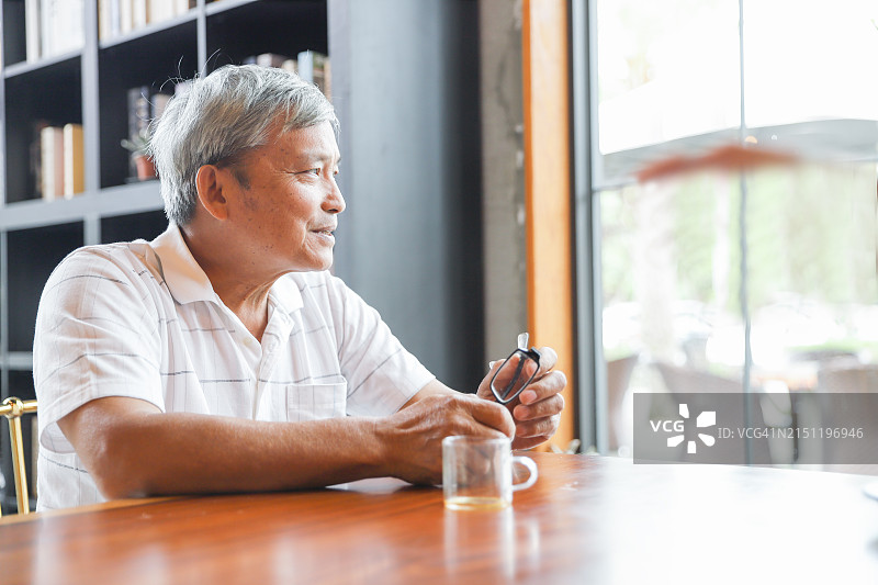 一位退休老人在咖啡馆喝茶图片素材