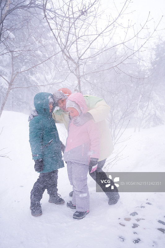 一家韩国人在暴风雪中行走图片素材