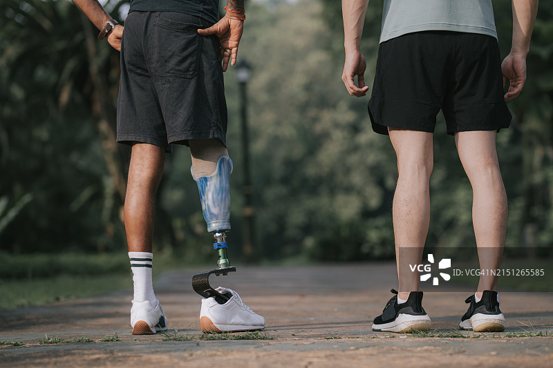 在公园里站立的残疾运动员和朋友的后视图图片素材