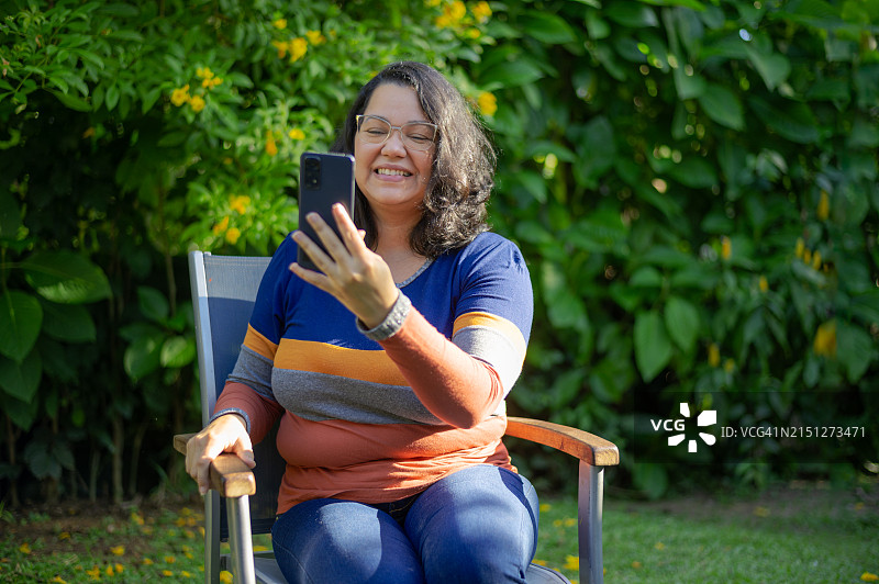 在线视频会议后，女人向同事炫耀她美丽的后院图片素材