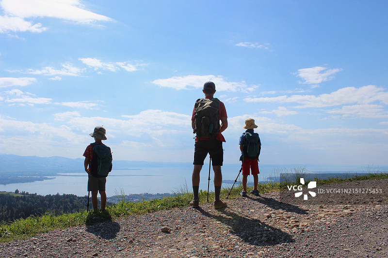 父亲带孩子们徒步旅行，欣赏湖泊全景图片素材