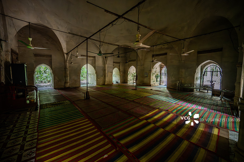 巴盖尔哈特Goaldi清真寺内部：条纹祈祷地毯、优美的拱门和彩色玻璃窗为朝拜者营造了一个宁静的历史避难所图片素材