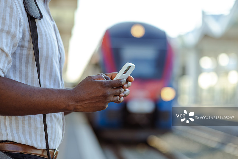 火车站使用智能手机的非裔美国男人特写图片素材