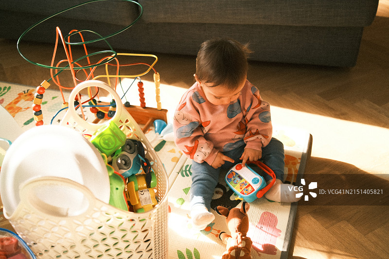 小男孩在客厅里玩许多玩具图片素材