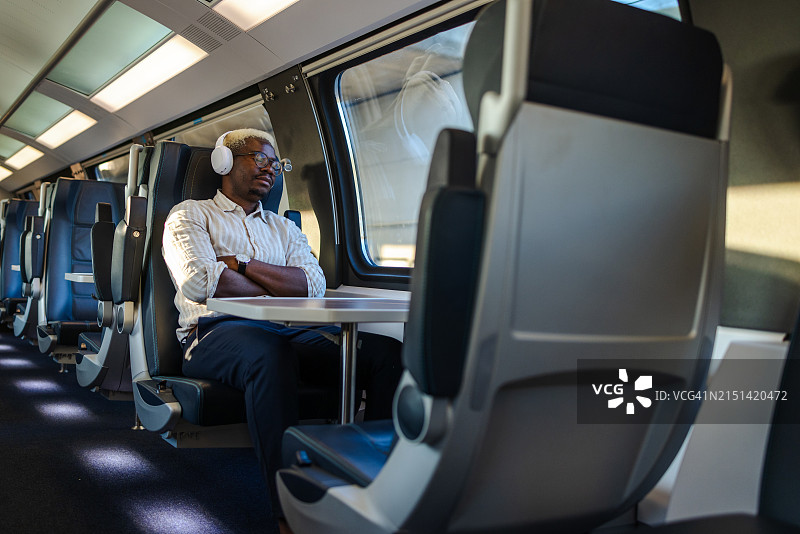 在火车上睡觉的非裔男通勤者图片素材