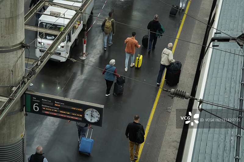 仅限编辑使用。乘客携带行李箱准备登上高速列车，可持续交通图片素材
