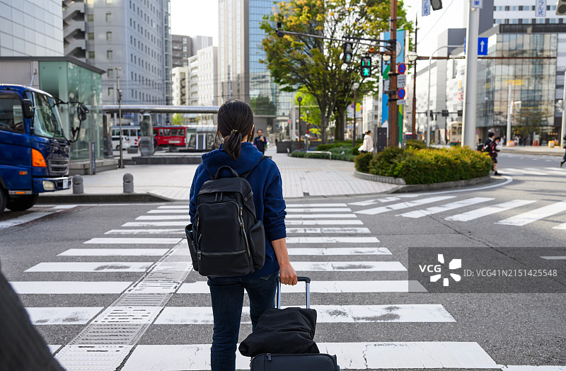 独自旅行，拖着行李箱的亚洲女性图片素材