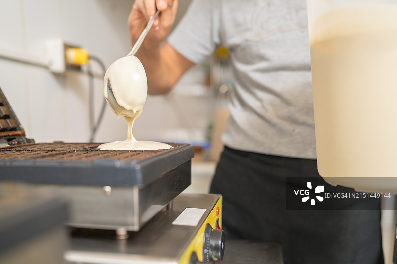 厨师将华夫饼面糊倒入华夫饼机中图片素材