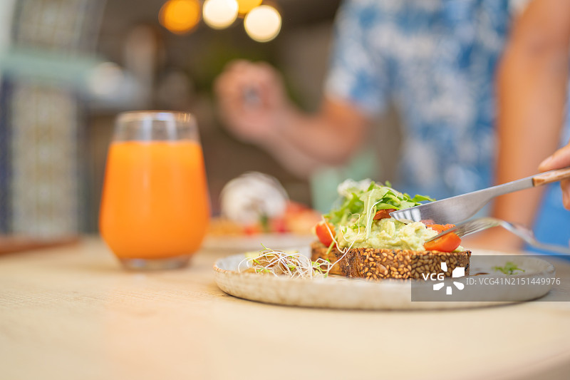 顾客在餐厅享用牛油果吐司和果汁图片素材