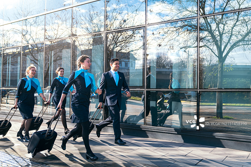 快速移动的航空公司机组人员和机长奔向航站楼图片素材