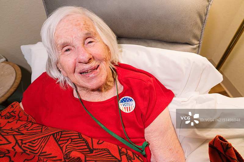 快乐的年长女性，102岁，佩戴“我已投票”贴纸图片素材