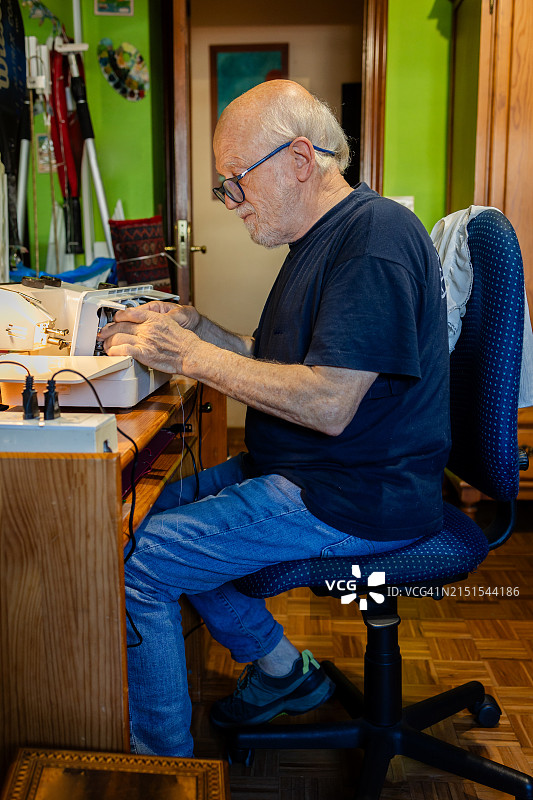 在工作室使用缝纫机的年长男人图片素材