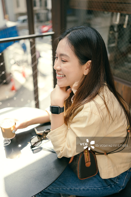 亚洲女性，30多岁，在咖啡馆享受特色咖啡图片素材