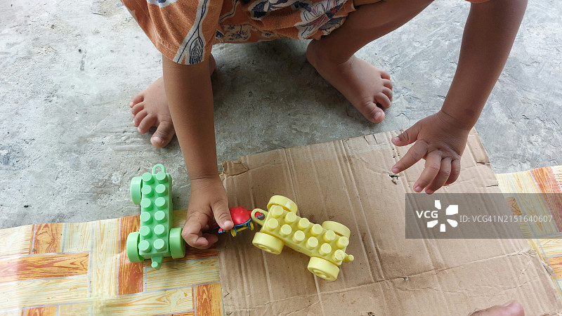 独自在地板上玩玩具的儿童图片素材