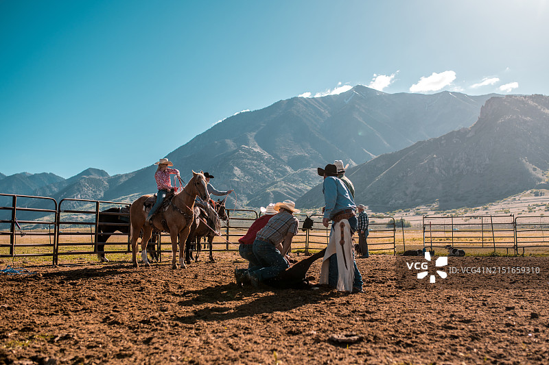 在美式乡村农场工作的不同种族牛仔图片素材