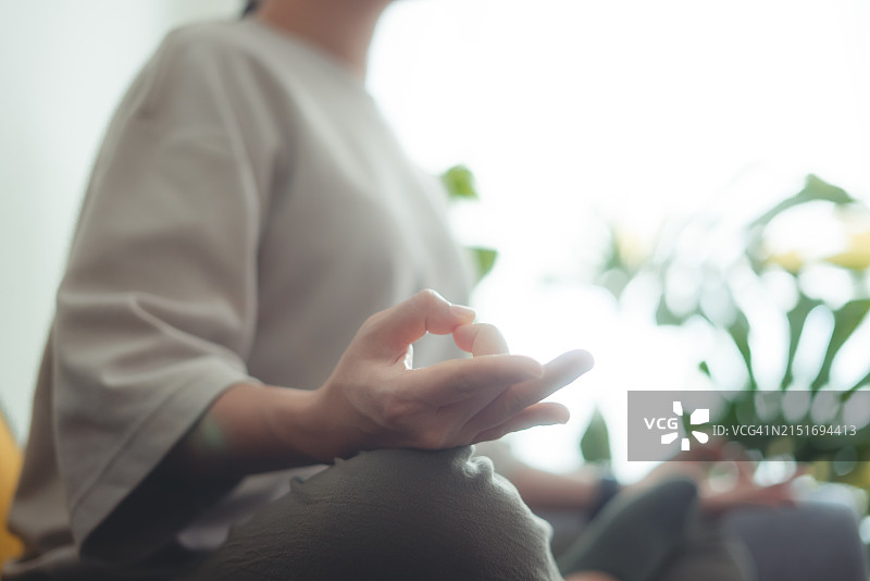 女子在家中客厅练习瑜伽冥想特写图片素材