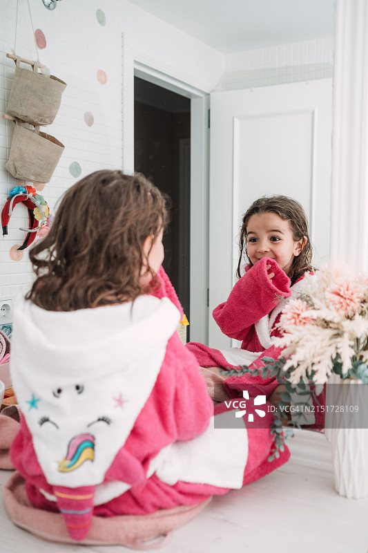 洗澡后照镜子的6岁女孩图片素材