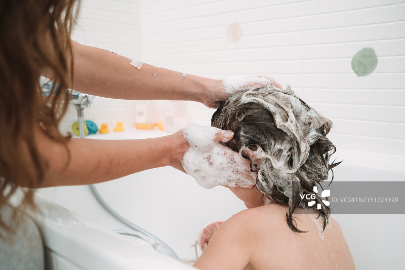 白人母亲在浴缸里给女儿洗头图片素材